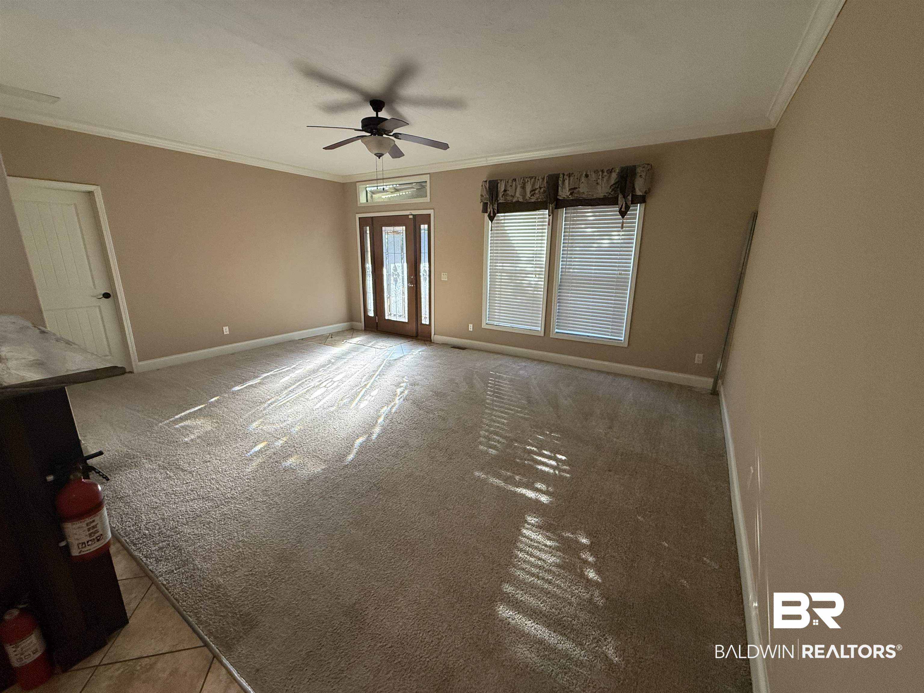 1274 Caney Loop Lillian, AL 36549 - Photo 6 of 19 Empty room featuring crown molding, a ceiling fan, light colored carpet, french doors, and light tile patterned floors