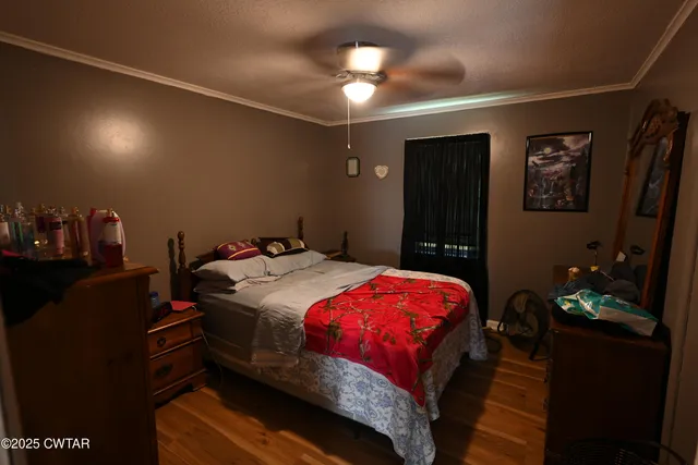 a bedroom with a bed and a lamp on dresser