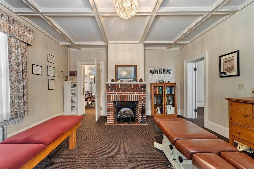 741 Salem Street Lynnfield, MA 01940 - Photo 11 of 41 a living room with furniture gym equipment and a fireplace