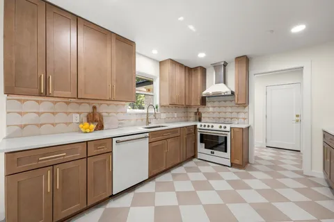 a kitchen with stainless steel appliances granite countertop a stove a sink and a refrigerator