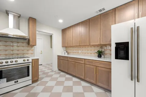 a kitchen with stainless steel appliances a stove a sink and a refrigerator