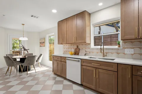 a kitchen with a sink dining table and chairs