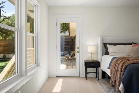 a bedroom with a bed and a large window with outer view