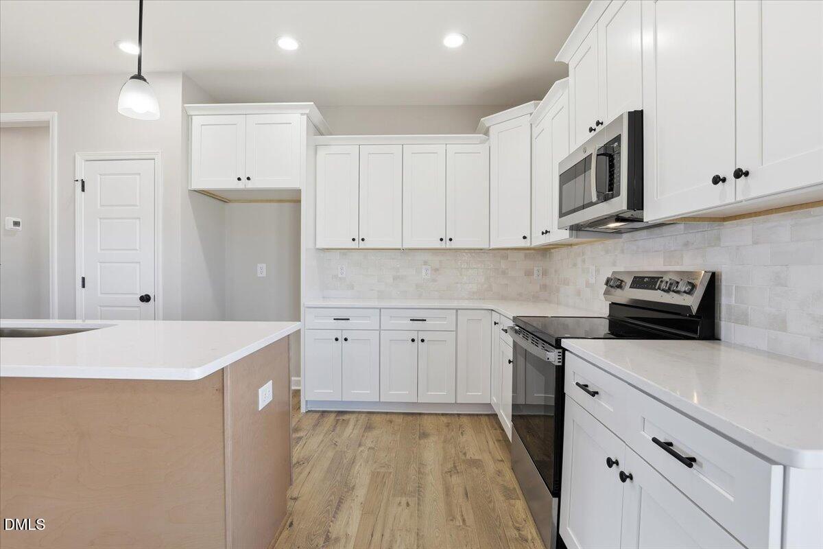 3696 Drew Farmer Road La Grange, NC 28551 - Photo 11 of 35 a kitchen with stainless steel appliances granite countertop a sink dishwasher a refrigerator and white cabinets with wooden floor