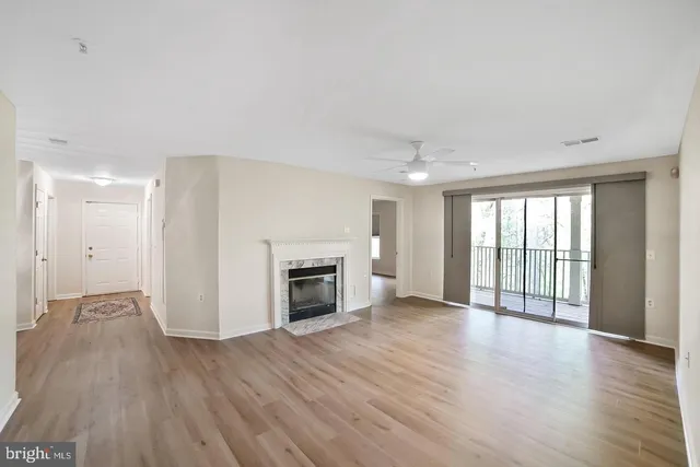 a view of an empty room with a fireplace and a window