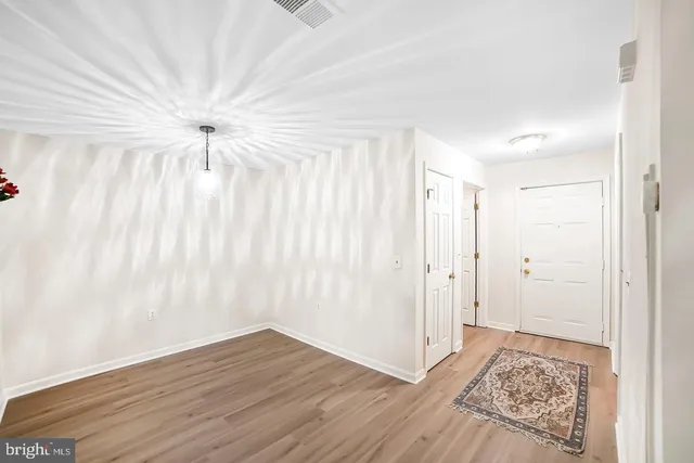 a view of a room with wooden floor and a ceiling fan