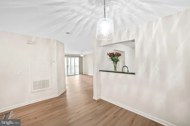 a view of an empty room with wooden floor