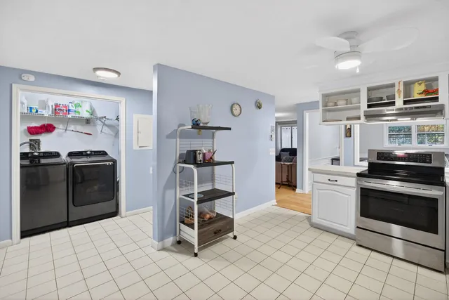 a kitchen with stainless steel appliances a stove a chimney a sink and cabinets