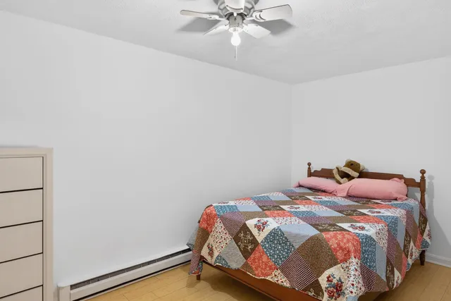a bedroom with a bed and a chandelier fan