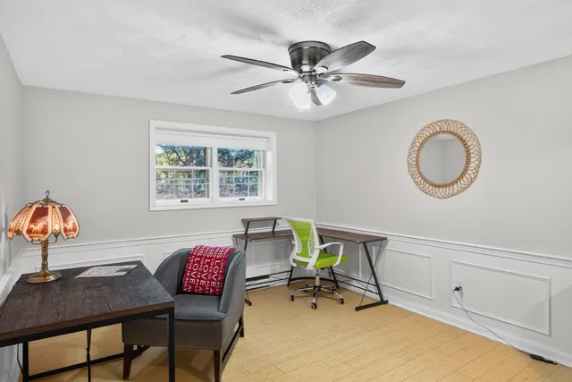 a view of a workspace with furniture and a window