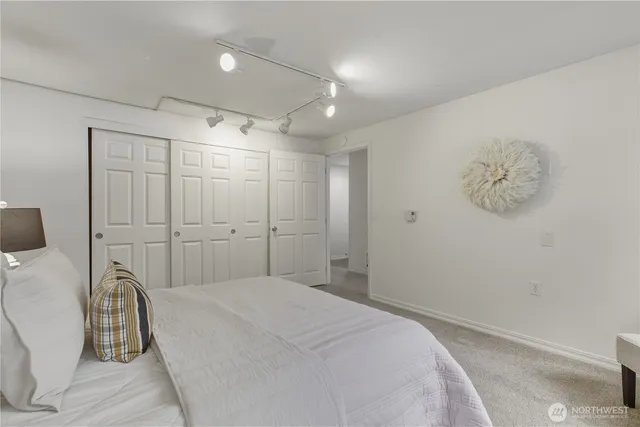 a spacious bedroom with a bed and a chair