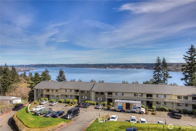 a front view of a building with cars parked