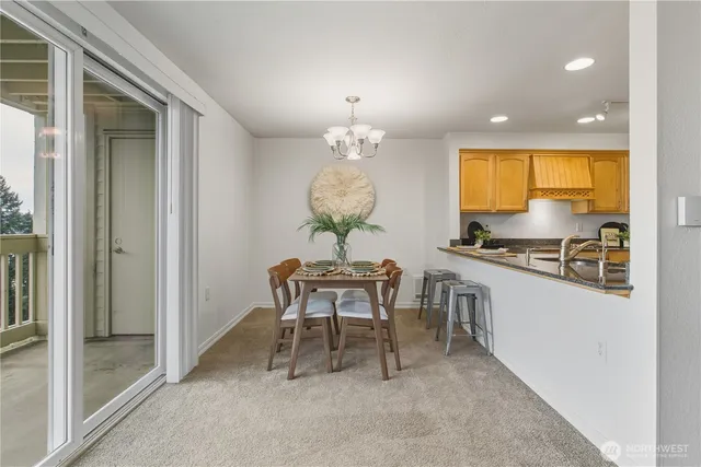 a dining room with furniture a chandelier and a window
