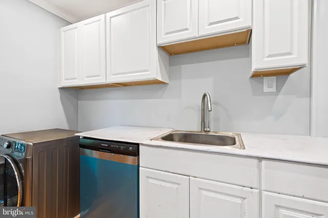 a kitchen with stainless steel appliances granite countertop a sink and a white cabinets