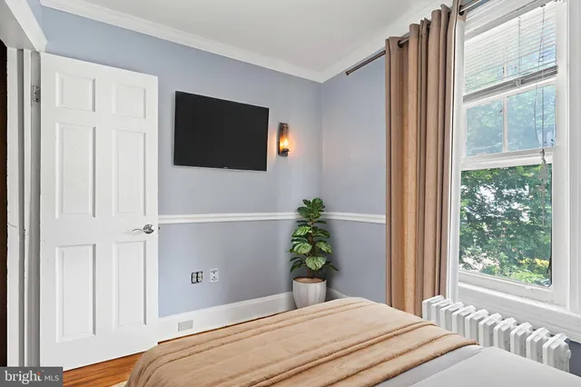 a bedroom with a bed and a potted plant
