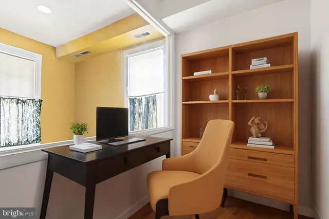 a view of a workspace with furniture and a window