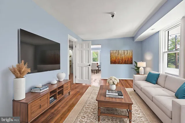 a living room with furniture a flat screen tv and a large window