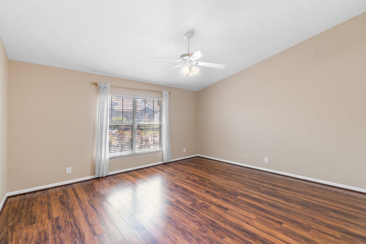 23458 Torre Circle Boca Raton, FL 33433 - Photo 15 of 36 a view of an empty room with wooden floor and a window