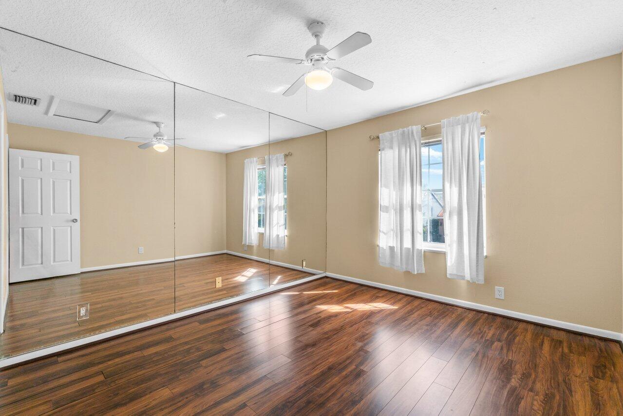 23458 Torre Circle Boca Raton, FL 33433 - Photo 25 of 36 a view of an empty room with a window and wooden floor