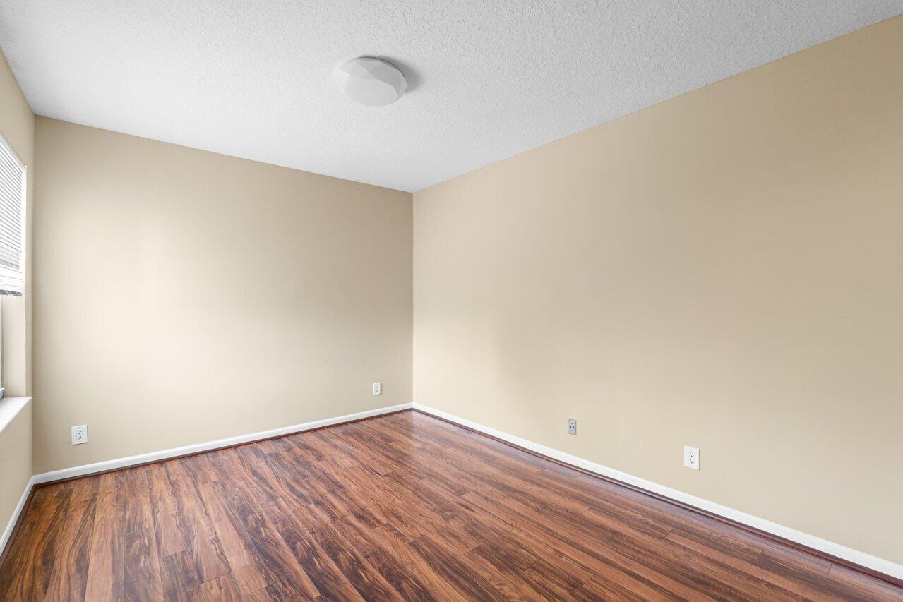 23458 Torre Circle Boca Raton, FL 33433 - Photo 29 of 36 a view of an empty room with wooden floor and a window
