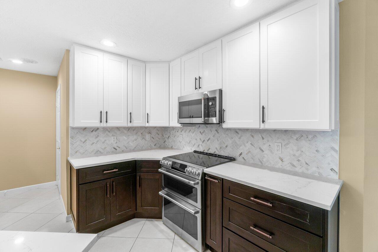 23458 Torre Circle Boca Raton, FL 33433 - Photo 8 of 36 a kitchen with granite countertop cabinets stainless steel appliances and a counter space