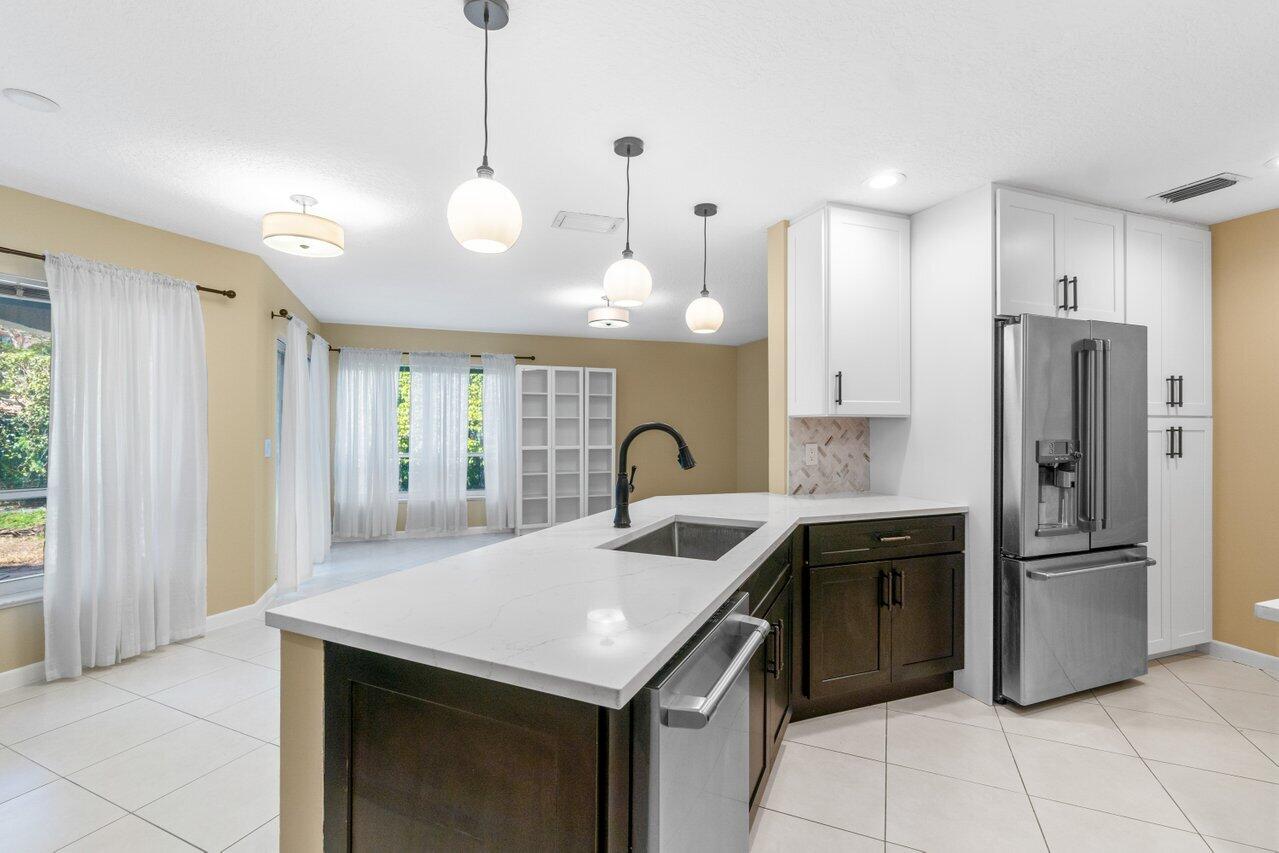 23458 Torre Circle Boca Raton, FL 33433 - Photo 9 of 36 a kitchen with stainless steel appliances granite countertop a sink a stove and a refrigerator
