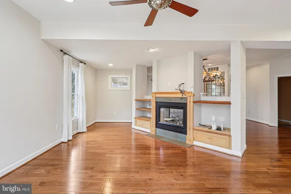 an empty room with a ceiling fan and window