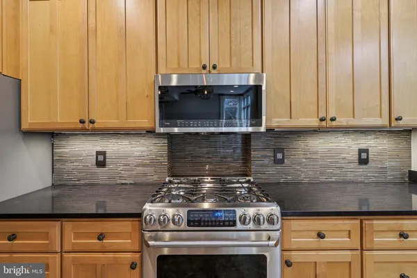 a view of an empty room and chandelier fan
