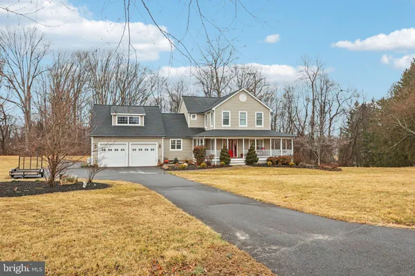 a view of an empty room with wooden floor and windows
