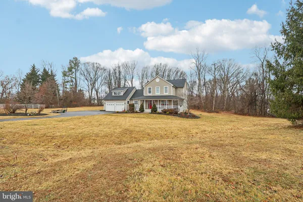 a view of a living room and kitchen with furniture wooden floor fireplace and a chandelier