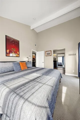 a bedroom with bed and paintings on the wall