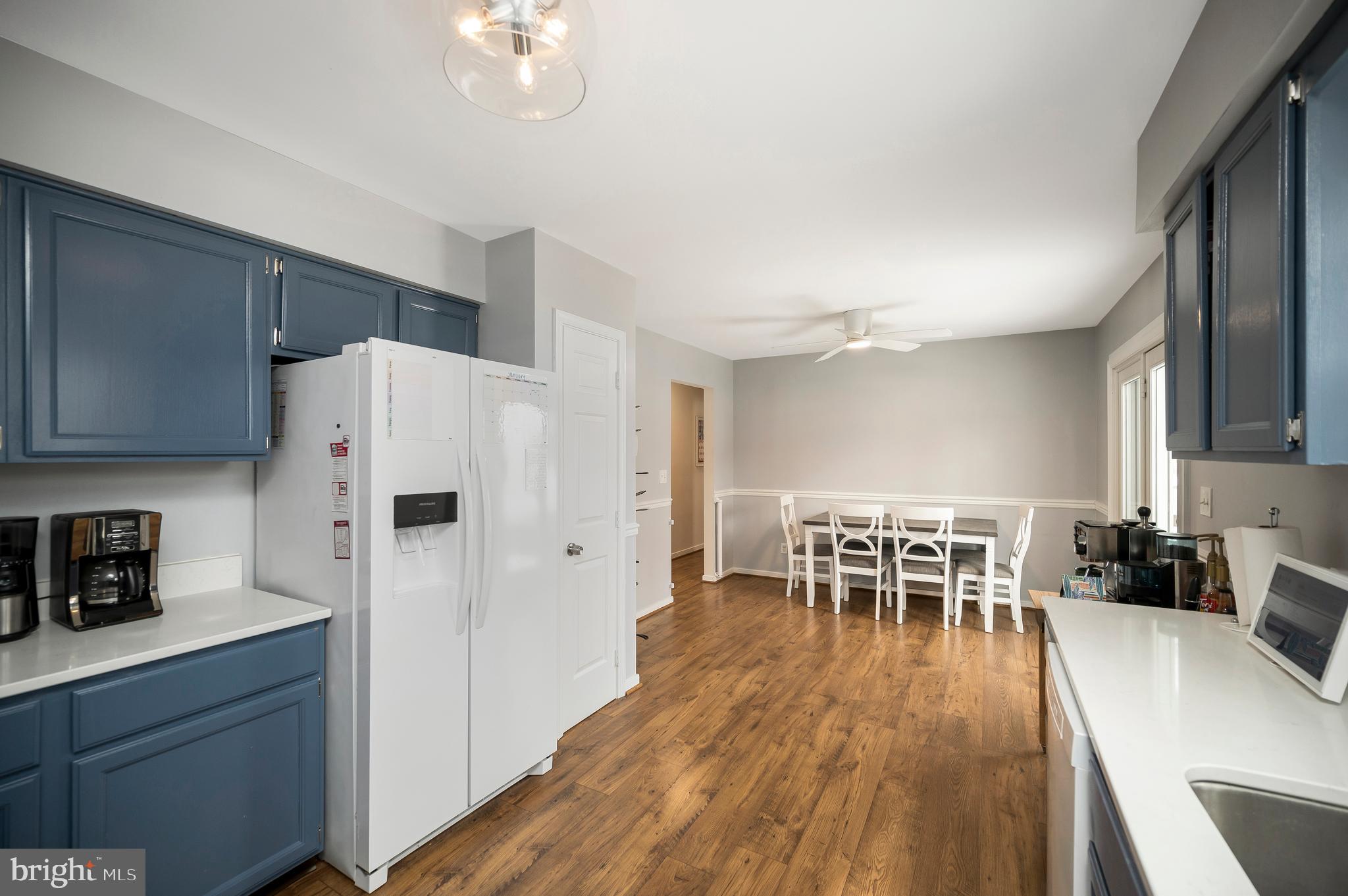 228 Choptank Road Stafford, VA 22556 - Photo 22 of 51 a kitchen with stainless steel appliances a refrigerator a stove a dining table and chairs with wooden floor
