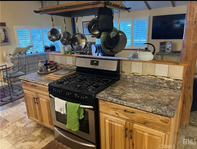 a kitchen with a stove and a wooden floor