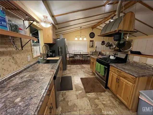 a kitchen with stainless steel appliances granite countertop a sink stove and cabinets