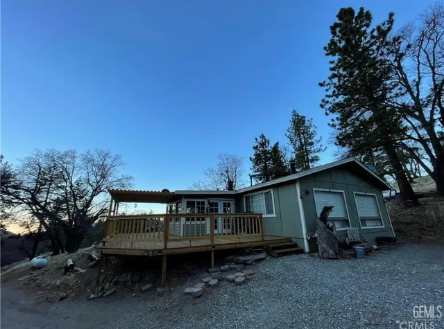 a view of a house with a yard and deck area