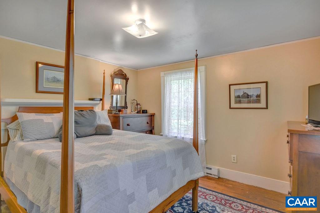 674 Octonia Road Stanardsville, VA 22973 - Photo 19 of 38 a bedroom with a bed and a chandelier