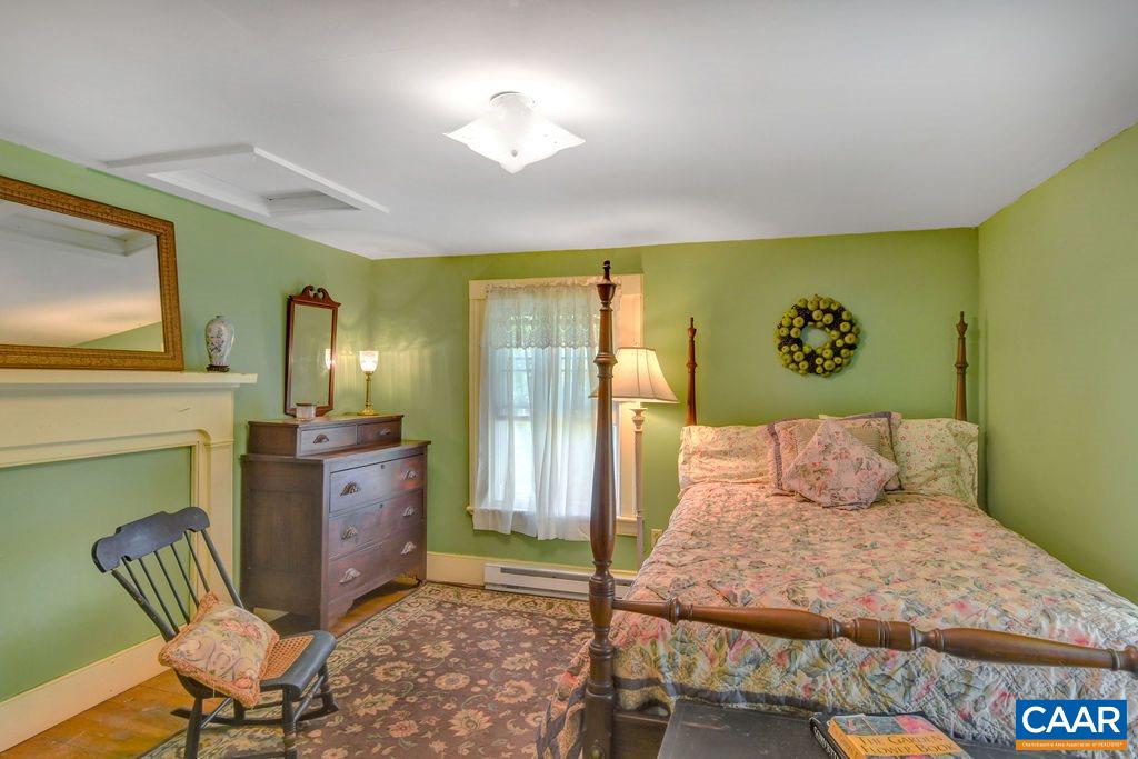674 Octonia Road Stanardsville, VA 22973 - Photo 24 of 38 a bedroom with a bed and wooden floor