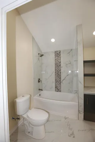 a bathroom with a toilet and a shower