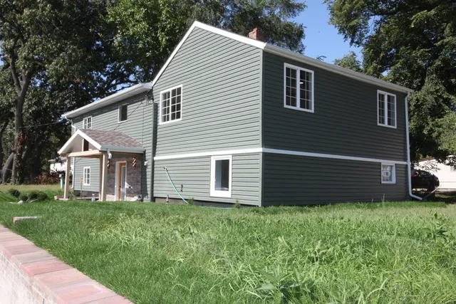 a view of a house with a yard and pathway