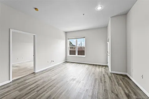 an empty room with a window and a ceiling fan