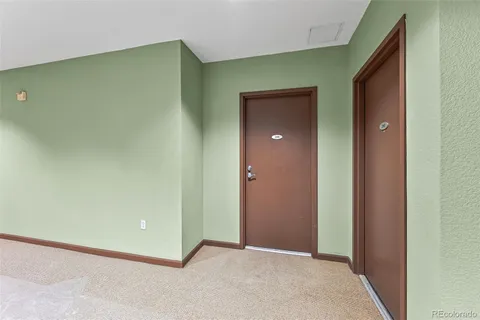 a view of a kitchen with white cabinets and refrigerator