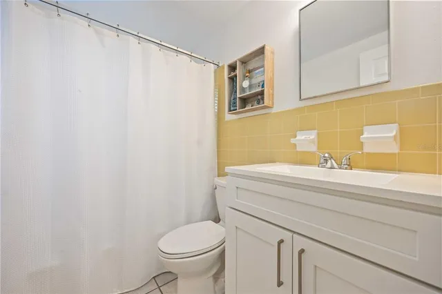 a bathroom with a sink a toilet and a shower curtain
