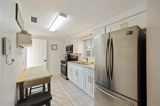 a kitchen with a refrigerator a sink and cabinets