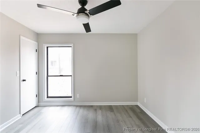 an empty room with a window and wooden floor