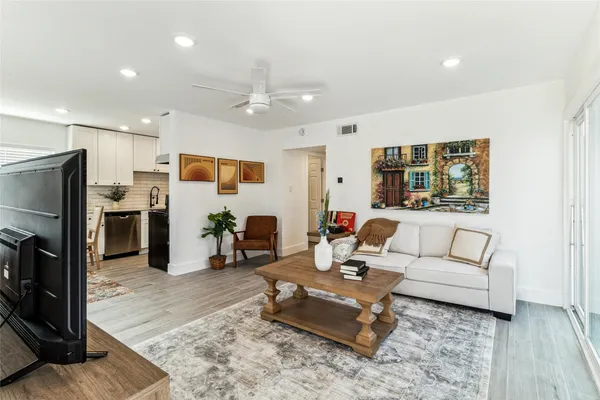 a living room with furniture kitchen view and a refrigerator