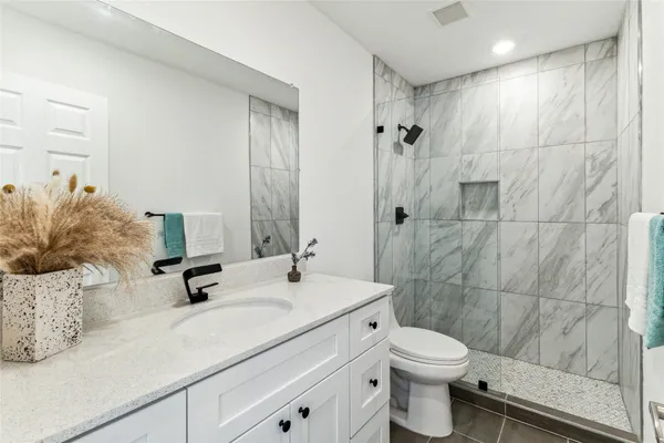 a bathroom with a sink a toilet and shower