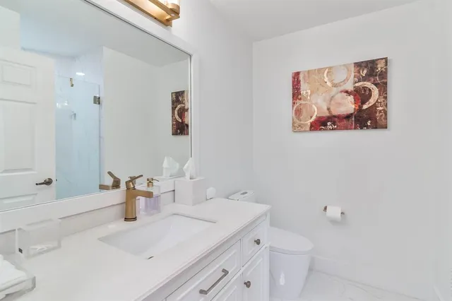 a bathroom with a sink mirror and toilet