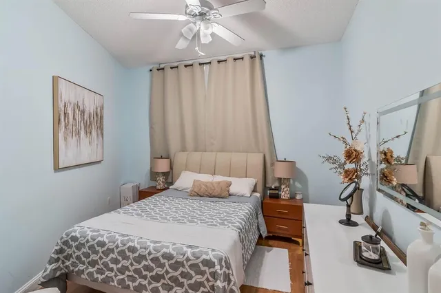 a bedroom with a bed and a flat tv screen on the dresser