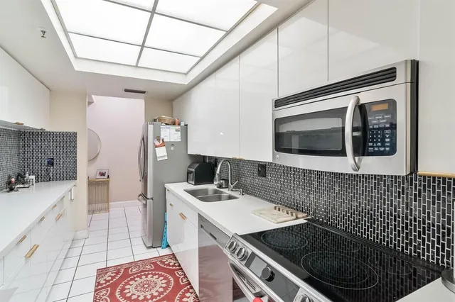 a bathroom with a sink a toilet a mirror and shower