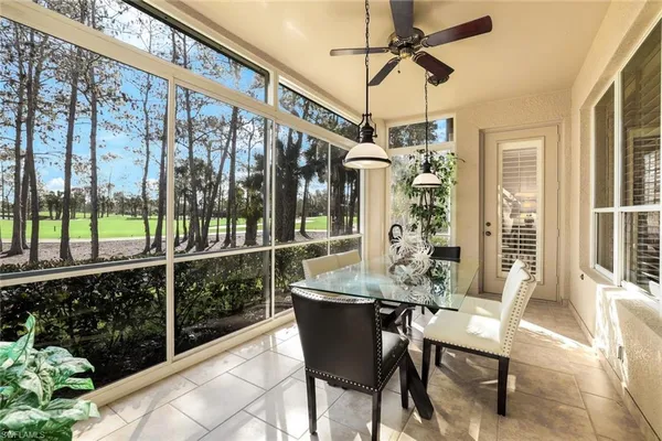 a dining room with glass top table and chairs